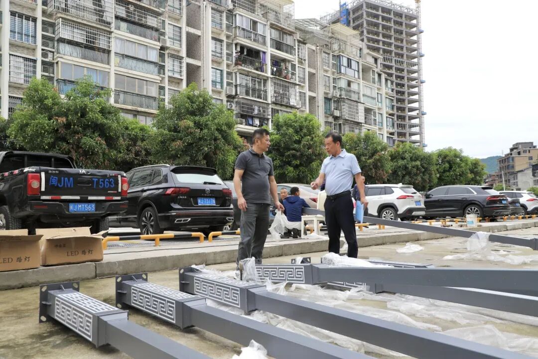 林兴金（右一）在就新设路灯与施工人员沟通